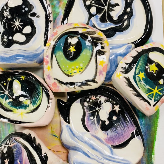 range of painted ceramic eye objects displayed with the camera moving to show their shine